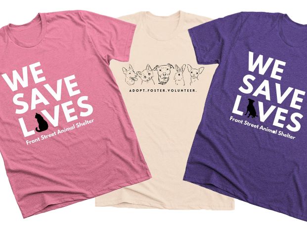 pink and purple shirts with We Save Lives on the front and a cream shirt with drawings of pets and the words Adopt Foster Volunteer on the front
