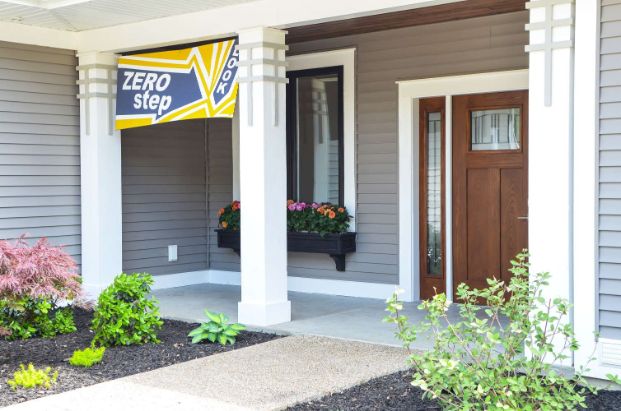 Pathway to the front door of a gray colored home, there is no step to the front door