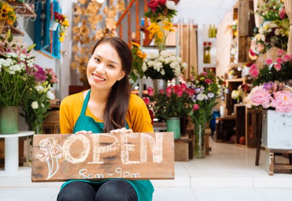 A woman holding an open sign