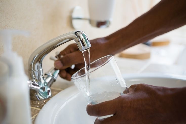 Image of person pouring water from a tap