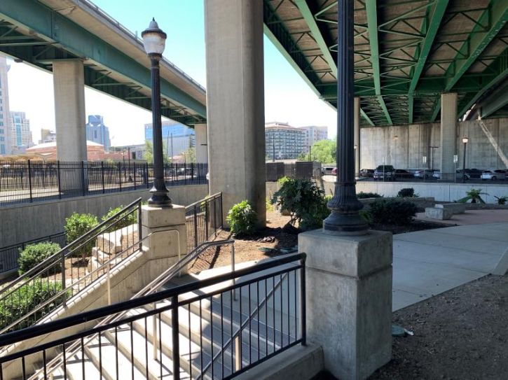 Freeway underpass, stair steps, plants, city in the background