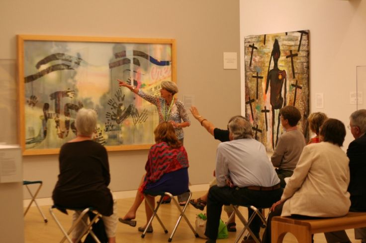 Group of people looking at a large painting in an art gallery