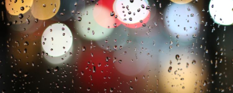 water drops on window with multi color lights behind window