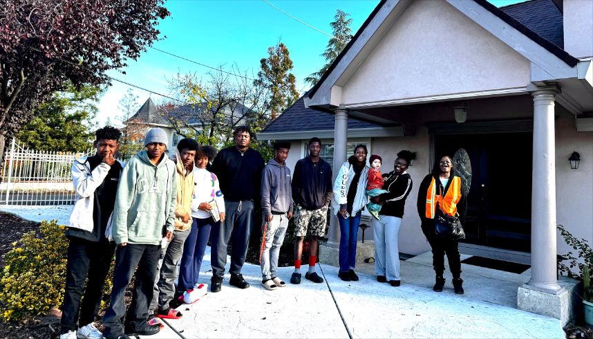 Family of 11 standing outside home