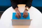 hands typing on blue laptop keyboard