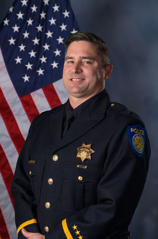 Photo of Sean Cunningham in uniform standing in front of the American flag.