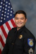 A portrait photo of the Sacramento Police Department Acting Lieutenant Ryan Enkoji, in full class-A uniform