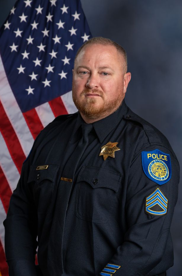 Photo of Dave Putman in uniform standing in front of the American flag.