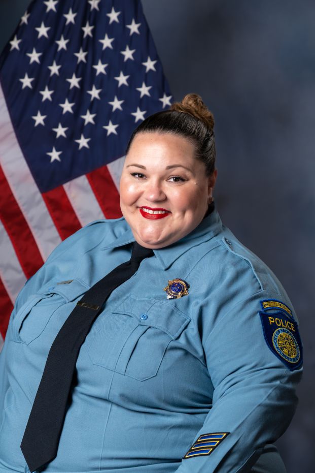 Photo of Beth Baron in class "A" uniform with the American flag in the background